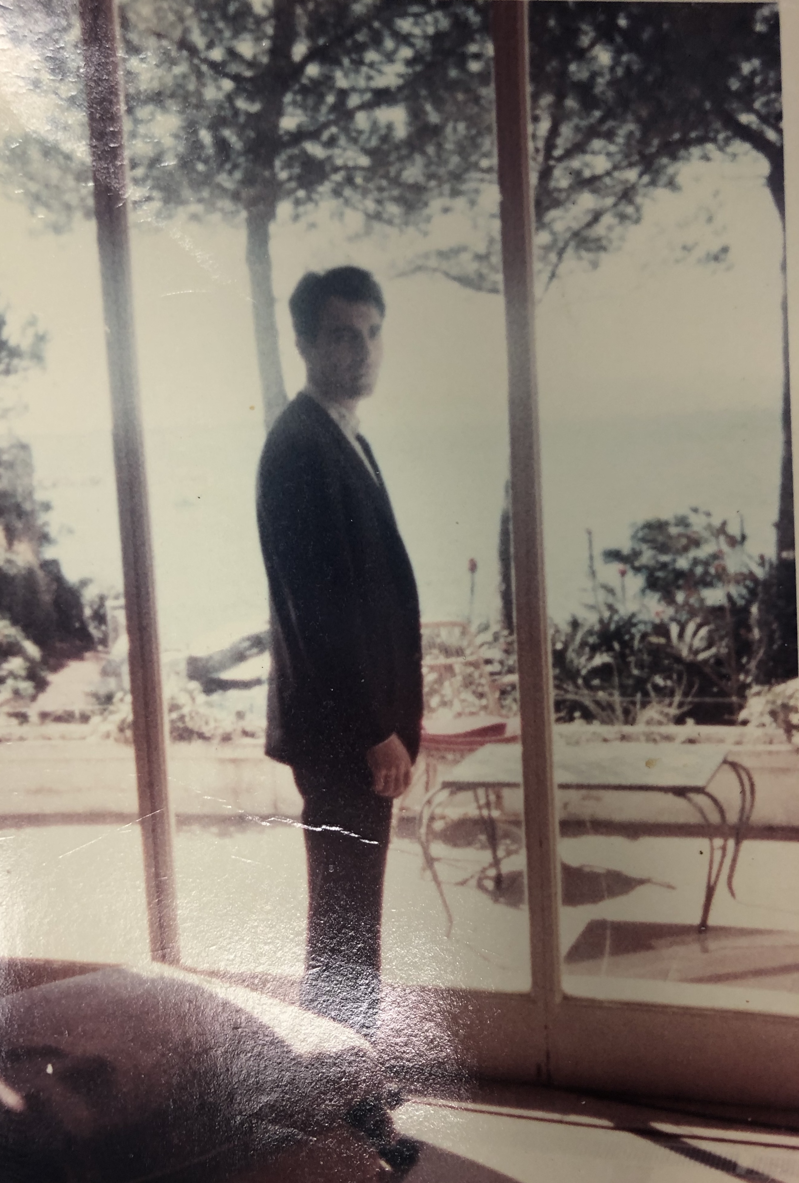 Robert silhouetted at a window overlooking the sea
